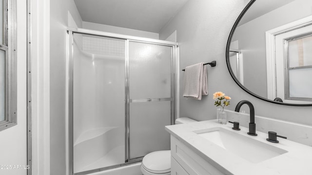full bathroom with vanity, a stall shower, and toilet