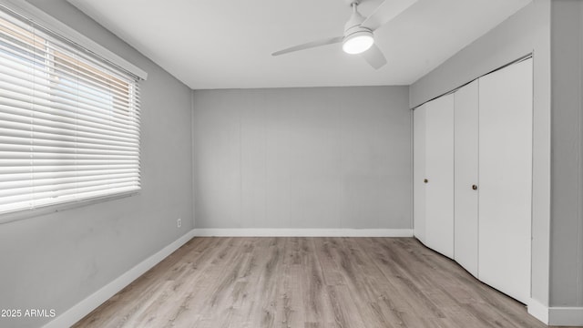 unfurnished bedroom featuring baseboards, ceiling fan, light wood-style flooring, and a closet