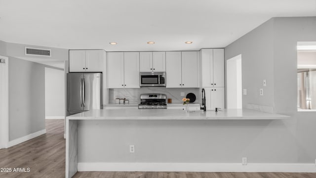 kitchen featuring visible vents, light countertops, baseboards, white cabinets, and stainless steel appliances