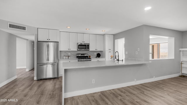 kitchen featuring visible vents, recessed lighting, white cabinetry, a sink, and stainless steel appliances