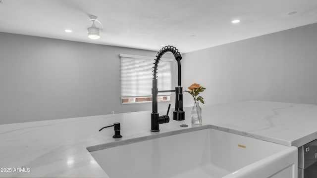 interior details featuring recessed lighting, a sink, white cabinets, and light stone countertops