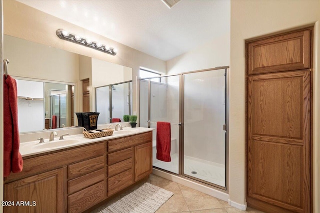 bathroom featuring tile patterned flooring, vanity, a shower with shower door, and a textured ceiling