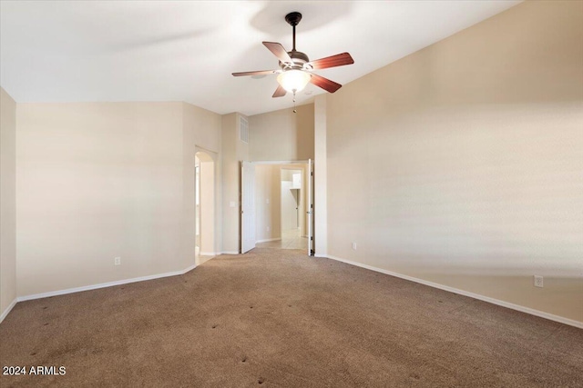 empty room with carpet floors, vaulted ceiling, and ceiling fan