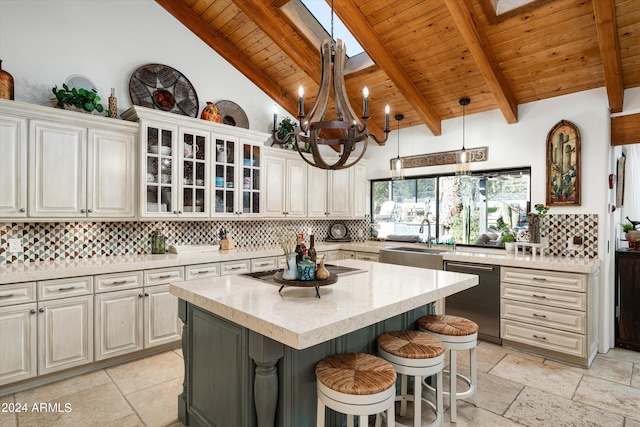 kitchen with a skylight, a kitchen island, black appliances, beam ceiling, and sink