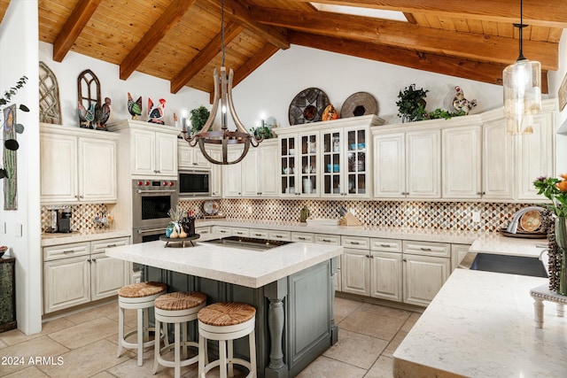 kitchen featuring white cabinets, a center island, stainless steel appliances, and beamed ceiling