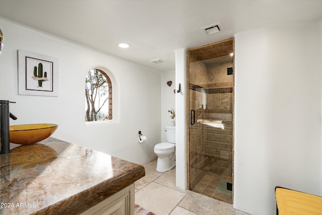 bathroom with toilet, walk in shower, and vanity