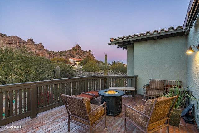 deck at dusk with an outdoor living space with a fire pit and a mountain view