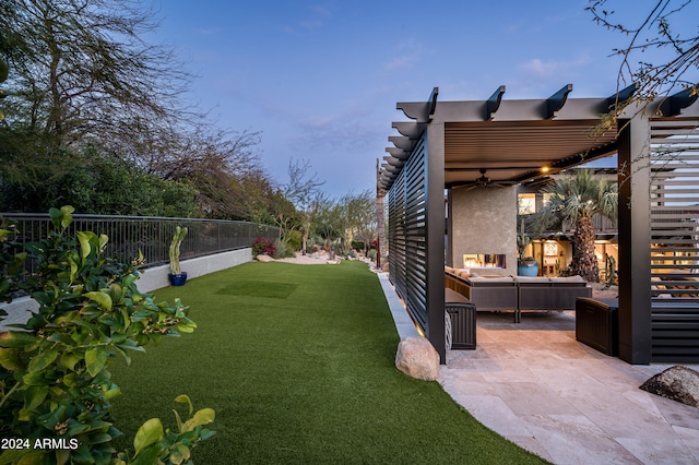 yard at dusk featuring a patio area and an outdoor living space with a fireplace