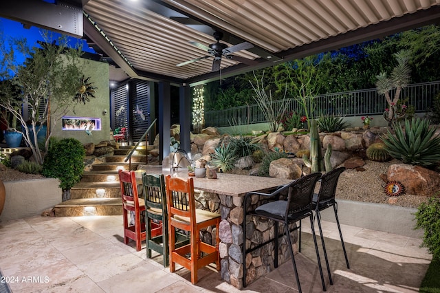 view of patio / terrace with ceiling fan and a bar