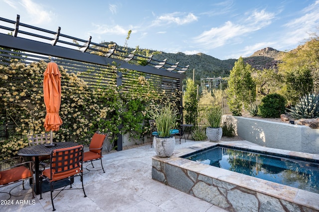 view of swimming pool featuring a pergola, a patio area, and a mountain view