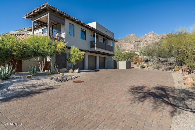 view of front of house featuring a mountain view and a balcony