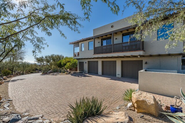 view of front of home with a garage and a balcony