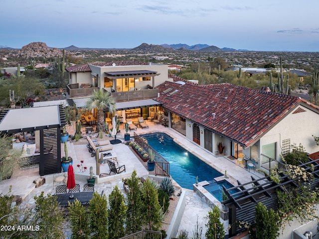 view of swimming pool with a patio area, a mountain view, and an in ground hot tub