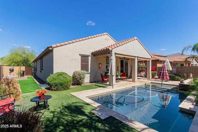 back of house with a fenced in pool, a fenced backyard, stucco siding, a tile roof, and a patio area