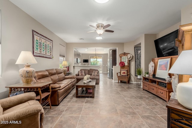 living area with light tile patterned floors, visible vents, ceiling fan with notable chandelier, and baseboards