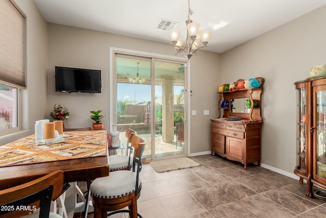 dining room with tile patterned floors, visible vents, baseboards, and a notable chandelier