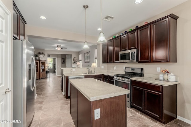 kitchen featuring visible vents, a peninsula, dark brown cabinets, appliances with stainless steel finishes, and a center island