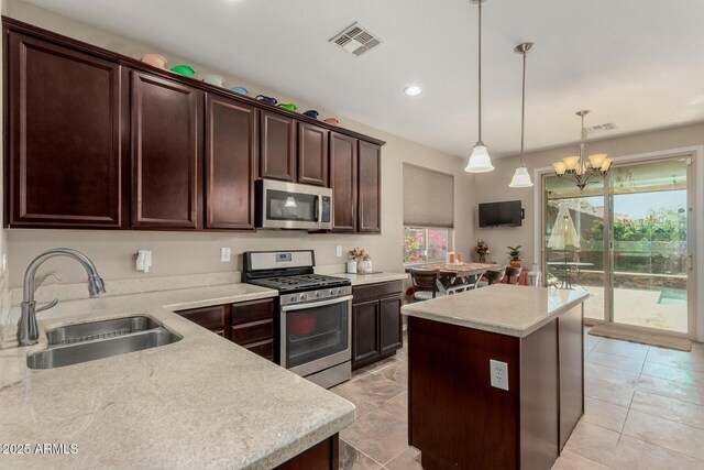 kitchen featuring a sink, a kitchen island, visible vents, and stainless steel appliances