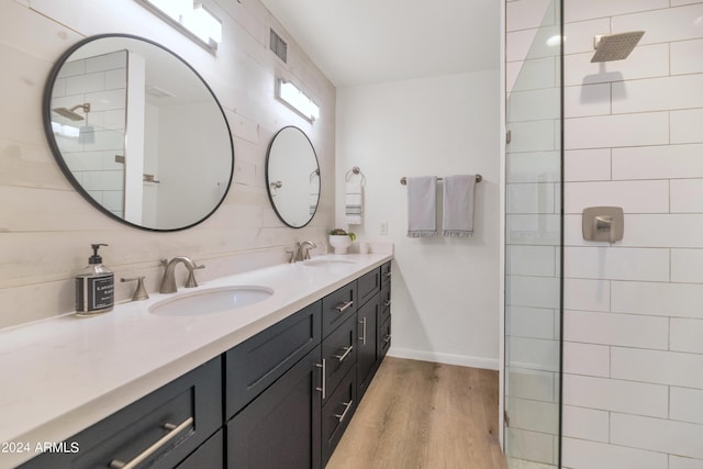 bathroom featuring a shower, vanity, wood walls, and hardwood / wood-style flooring