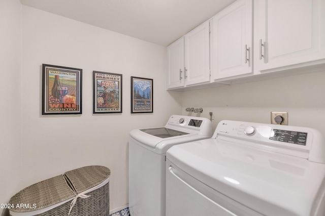 clothes washing area featuring cabinets and washing machine and clothes dryer