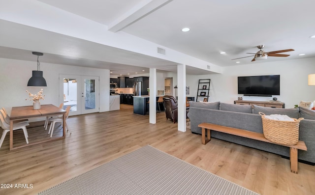 living room featuring hardwood / wood-style flooring, ceiling fan, beam ceiling, and french doors