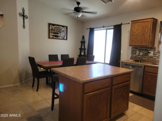 1769 E Jacob St, San Tan Valley, AZ 85140 - kitchen featuring dishwasher, decorative backsplash, ceiling fan, a center island, and a breakfast bar area