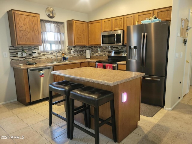 1769 E Jacob St, San Tan Valley, AZ 85140 - kitchen with appliances with stainless steel finishes, tasteful backsplash, a sink, light tile patterned floors, and a center island