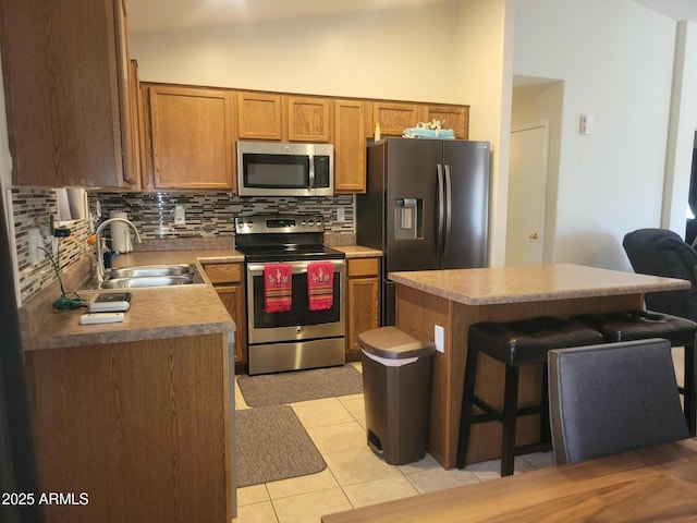 1769 E Jacob St, San Tan Valley, AZ 85140 - kitchen with stainless steel appliances, a sink, tasteful backsplash, a kitchen island, and a breakfast bar area