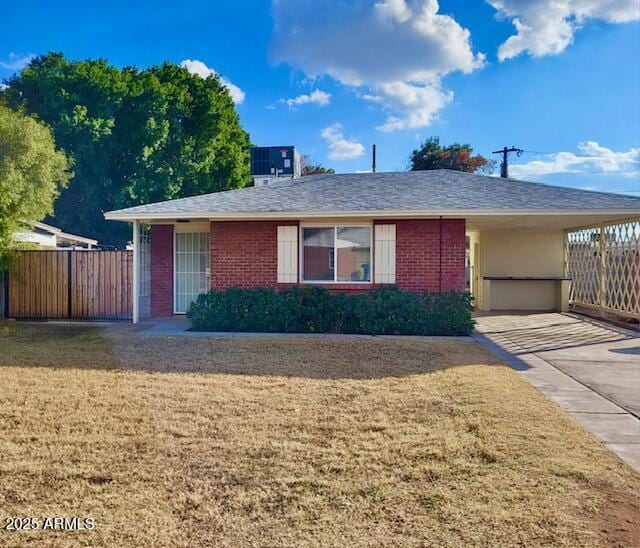 single story home featuring central AC, a front lawn, and a carport