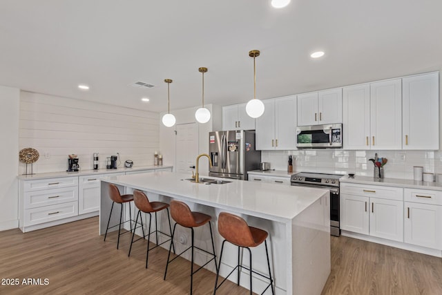 2033 E Janice Way, Phoenix, AZ 85022 - kitchen with appliances with stainless steel finishes, a breakfast bar, decorative backsplash, a sink, and light countertops