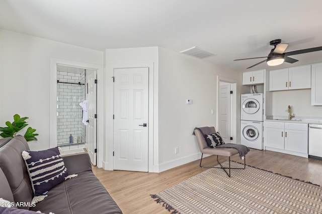 2033 E Janice Way, Phoenix, AZ 85022 - living room featuring stacked washing machine and dryer, light wood finished floors, ceiling fan, and baseboards