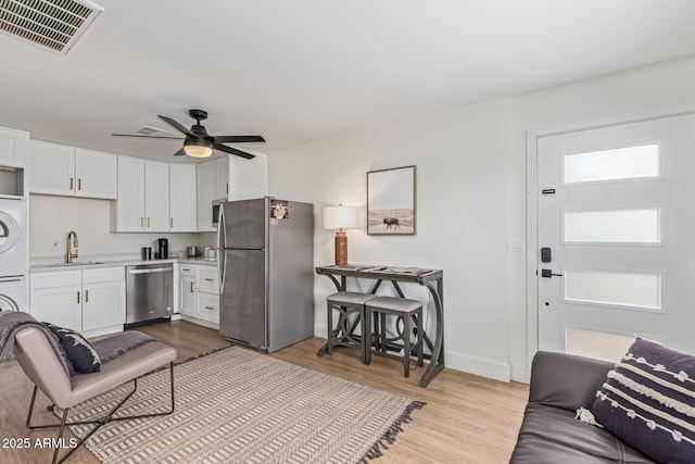 2033 E Janice Way, Phoenix, AZ 85022 - living room featuring stacked washing machine and dryer, light wood-style floors, baseboards, and ceiling fan