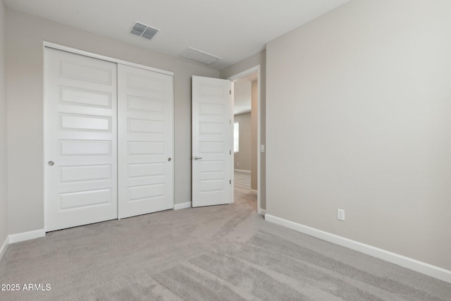 unfurnished bedroom featuring a closet, visible vents, carpet flooring, and baseboards