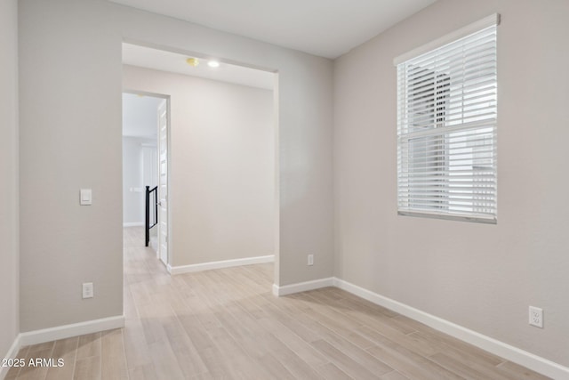 empty room featuring light wood-style flooring and baseboards