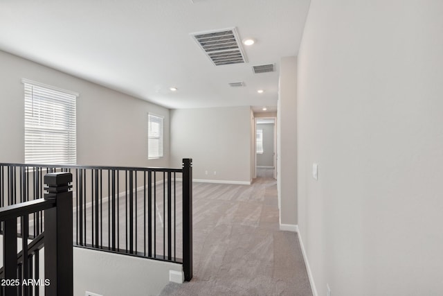 corridor featuring recessed lighting, baseboards, visible vents, and light carpet