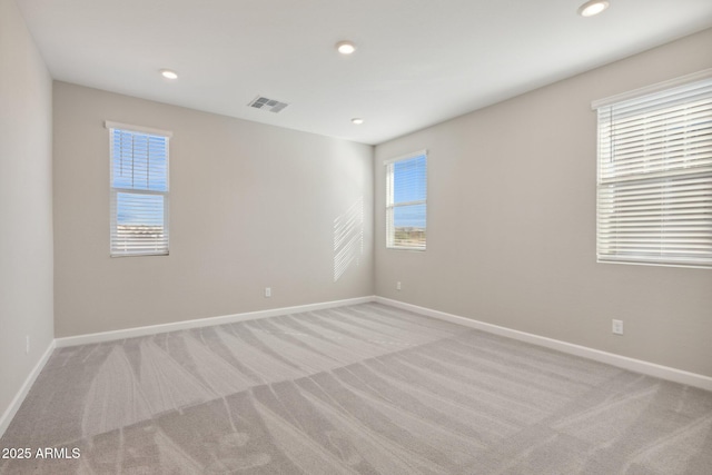 spare room with baseboards, recessed lighting, visible vents, and light carpet