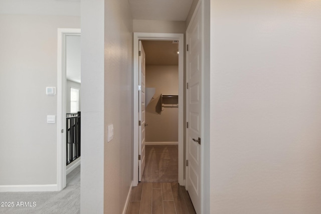 corridor featuring baseboards and wood finished floors