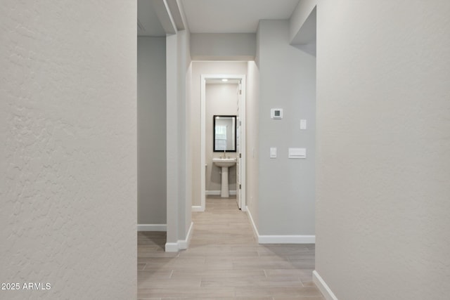 hall with baseboards and wood finish floors