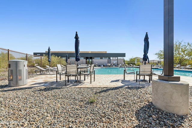 pool with a patio and fence