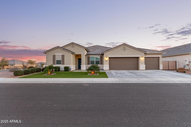 single story home with a garage and a lawn