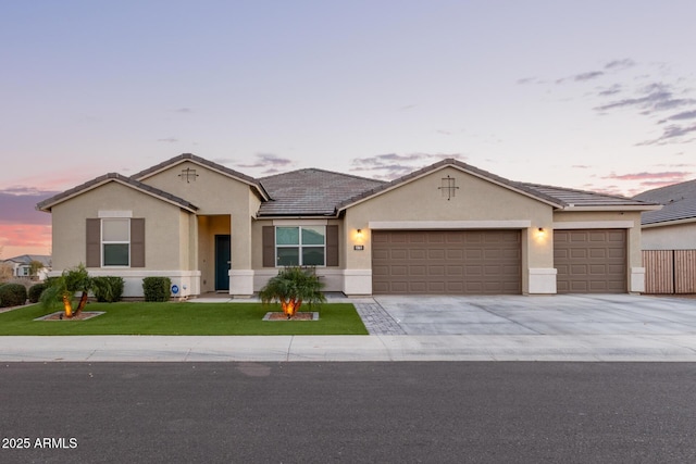 single story home with a garage and a yard