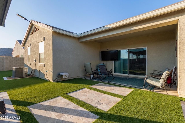 rear view of property featuring a patio, a yard, and central AC unit