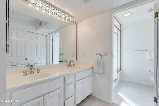 bathroom with vanity, toilet, tile patterned floors, and a shower with shower door