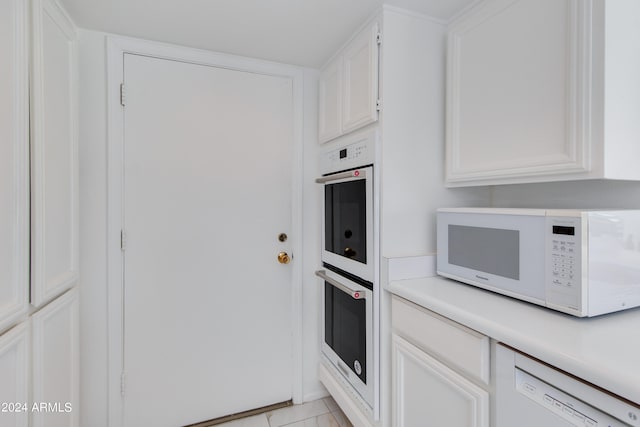 kitchen featuring white cabinets, light tile patterned flooring, and white appliances