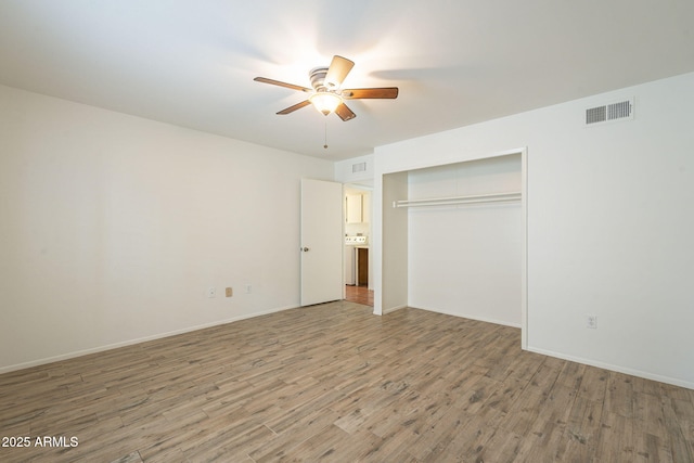 unfurnished bedroom featuring baseboards, visible vents, a closet, and light wood-type flooring