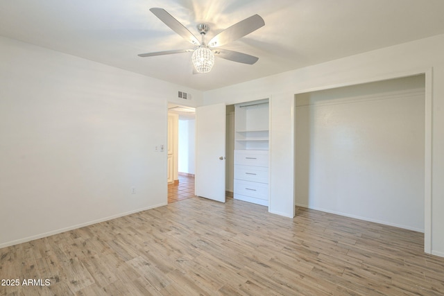 unfurnished bedroom with light wood finished floors, visible vents, baseboards, multiple closets, and a ceiling fan