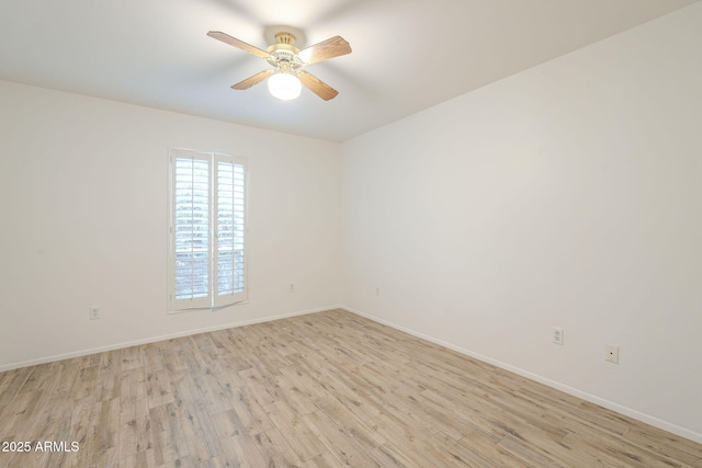 unfurnished room with light wood-style flooring, a ceiling fan, and baseboards