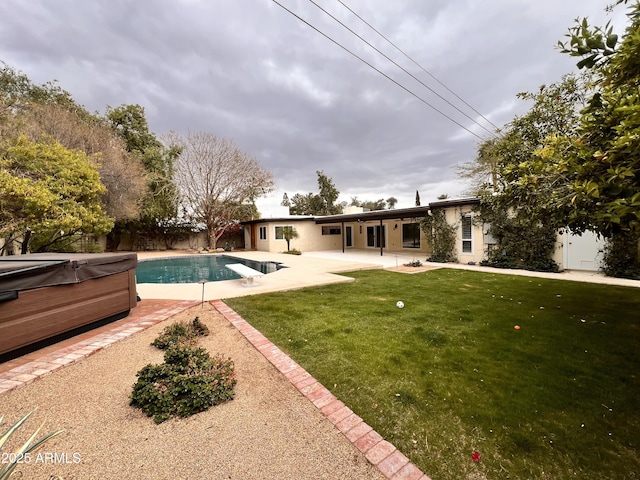 exterior space with a lawn, fence, a patio area, a diving board, and a hot tub