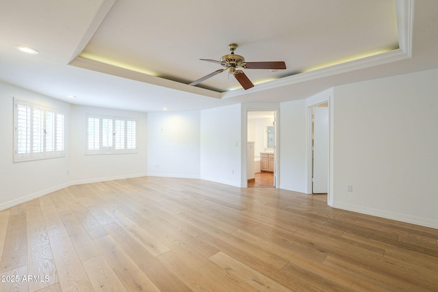 spare room with a ceiling fan, baseboards, a tray ceiling, recessed lighting, and light wood-style floors