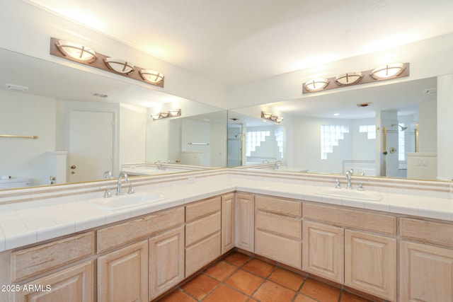 bathroom featuring double vanity, a stall shower, and a sink